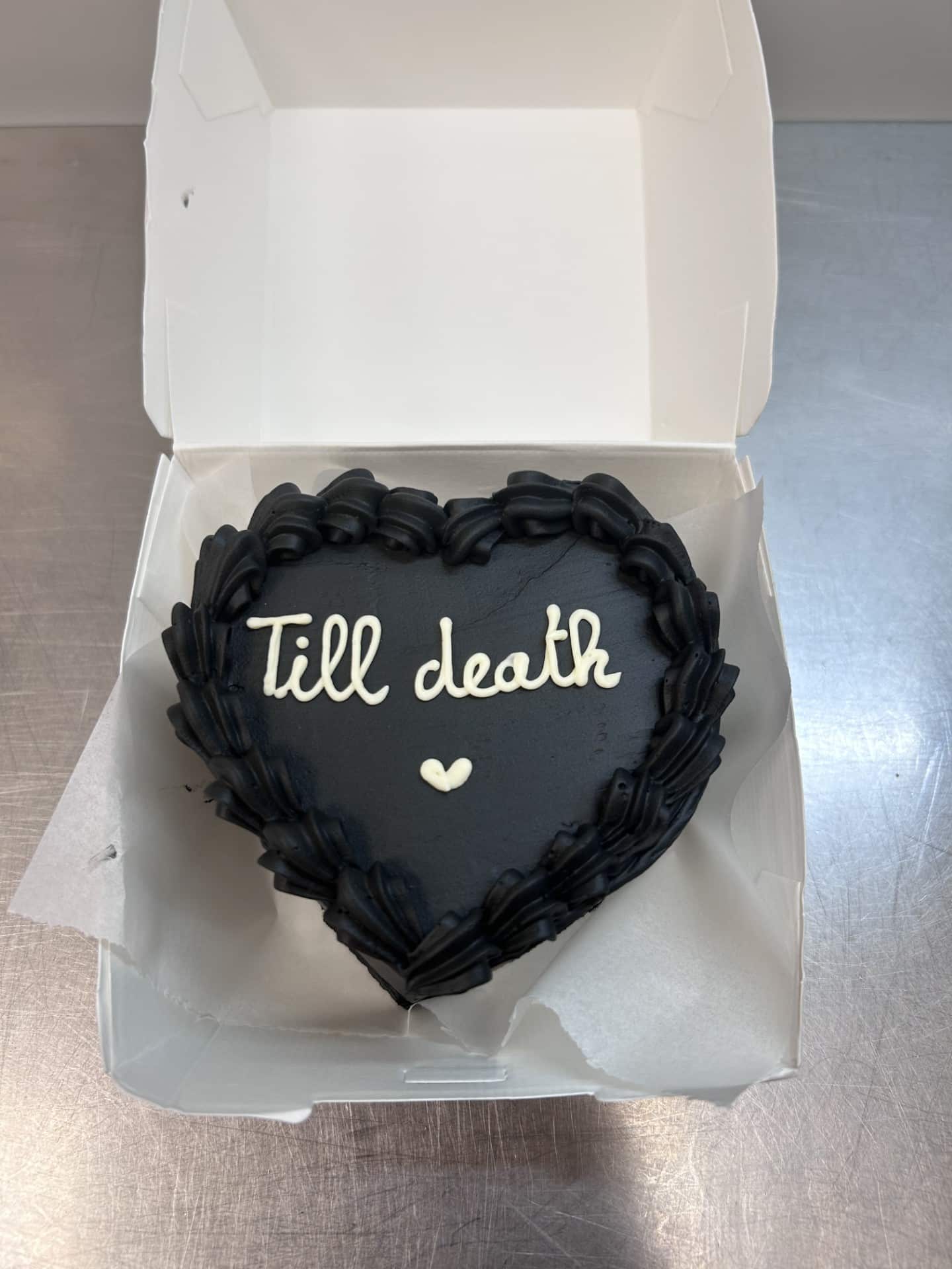 Gâteau cœur noir, glaçage blanc "Till death" et petit cœur, dans une boîte blanche. Style romantique et original.